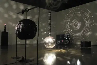 Installation in a dark room filled with mirrored balls.