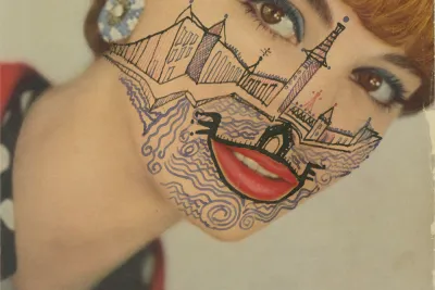 A photograph of a woman with a heavily tattooed face.