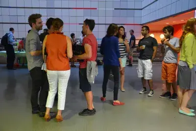 People socialize in the Wiesner Building Atrium during an art reception.