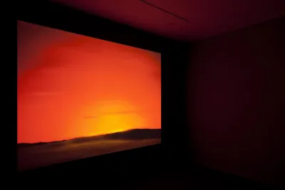 A very bright orange and yellow projection, the colors of a spectacular sunset, in a dark space