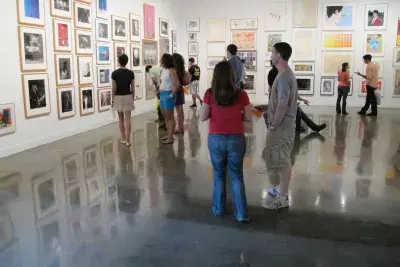 People stand in a gallery and converse with each other.