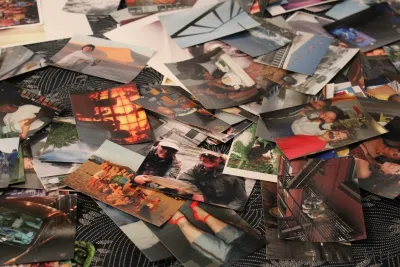 A variety of photos includes images of people and places, spread on a patterned tablecloth.