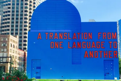 A blue mural on the side of a building reads &quot;A translation from one language to another.&quot;