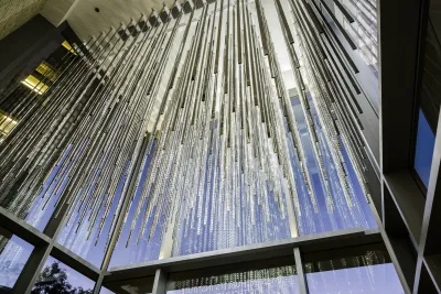 Many stainless steel rods are lit and photographed from under.