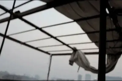 The silhouette of a building structure in front of a sky background.