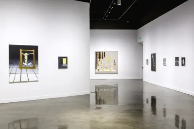 8 paintings of various sizes in muted tones installed on 3 white walls of the gallery