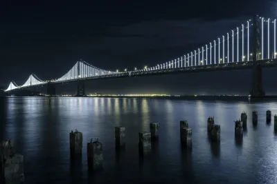 A photo of the San Francisco Bridge and bay at night.