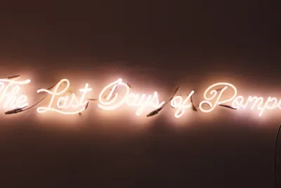 A pink neon sign says &quot;The Last Days of Pompeii&quot;.