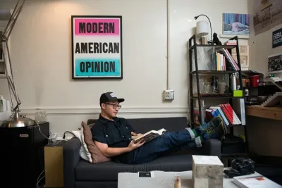 Student at a desk with a large artwork in the background.