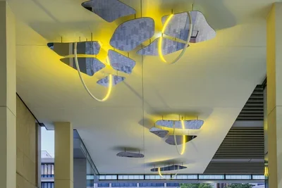 A ceiling bound sculpture of mirror and yellow lights by Olafur Eliasson is installed.