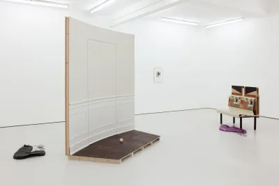 There are two sculptures consisting of wall molding and wood in a gallery space.