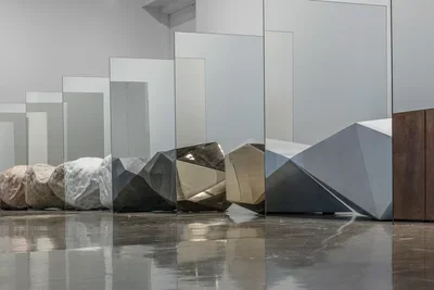 An installation including large rocks placed between sheets of mirror.