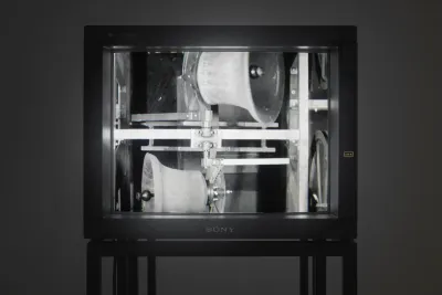 Close view of a video monitor showing a black and white image of two carillon bells ringing horizontally in opposite directions.