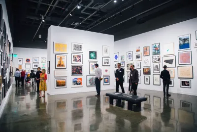 Visitors look at artwork on walls at the List Center galleries during the 2019 Student Lending Art Program exhibition.