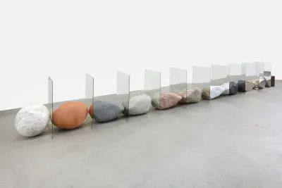 Colored geometric rocks and boulders are installed between vertical sheets of miror.