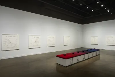 7 cushions ranging from reds to blues to purple with 7 headphones sit atop a white bench surrounded by 6 pie-chart drawings.