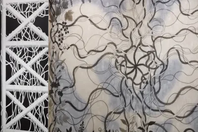 Detail view of painting with twisted grayscale vines intertwining with a pale blue background.