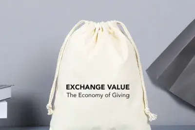 Black text on a white canvas drawstring bag reads &quot;Exchange Value: The Economy of Giving.&quot;