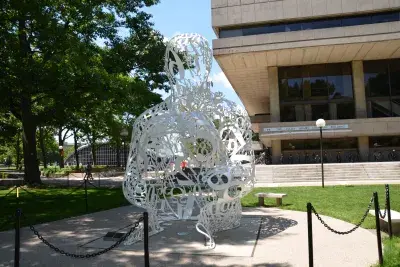 Sculpture made of tainless steel, white enamel paint featuring collages of letters, numbers, or symbols that appear to be in the process of organization.