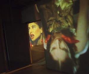 Installation view of Dimensions of the Mind featuring an image of a woman projected onto a wall. 