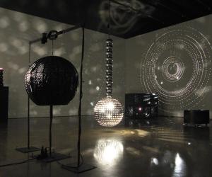 Installation in a dark room filled with mirrored balls.