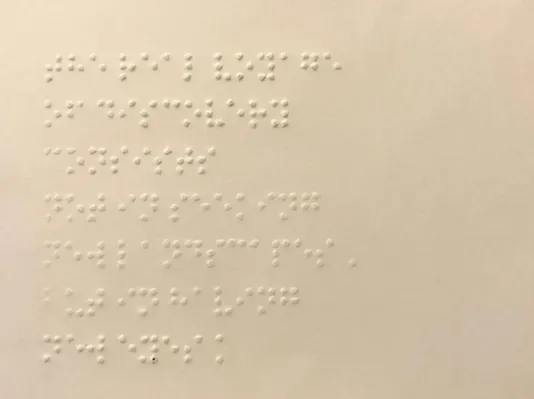 Cream colored postcard with Braille writing on it.