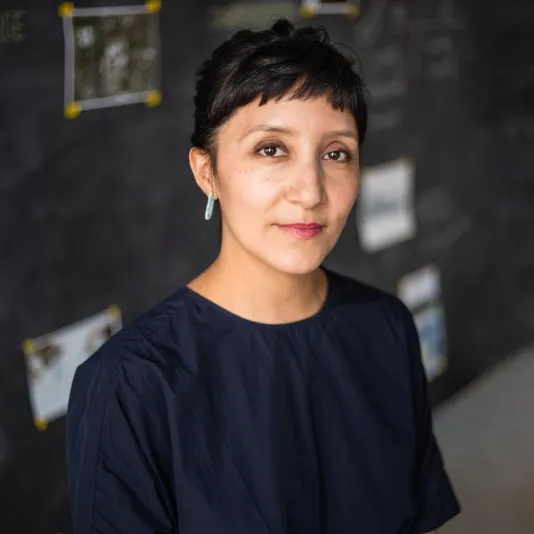 Headshot of Maria Gaspar with short dark hair wearing a navy blue shirt.
