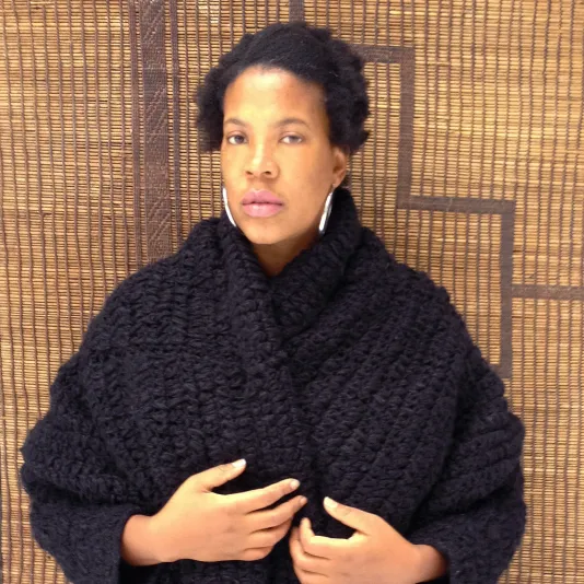 Headshot of Xavier Simmons wearing a black knitted shawl.