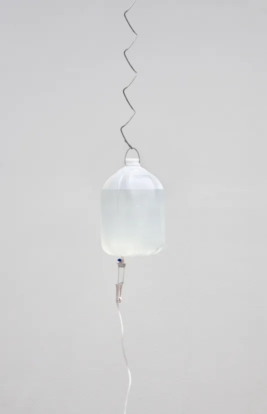 Chain link wire attached to a water bottle suspended in the air.