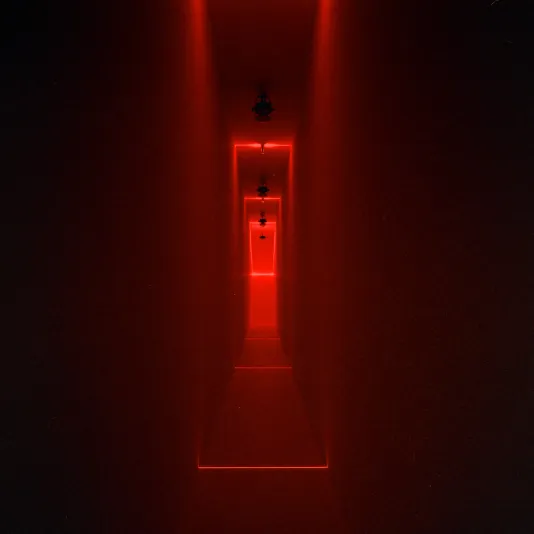 Long narrow hallway lit by deep red light.