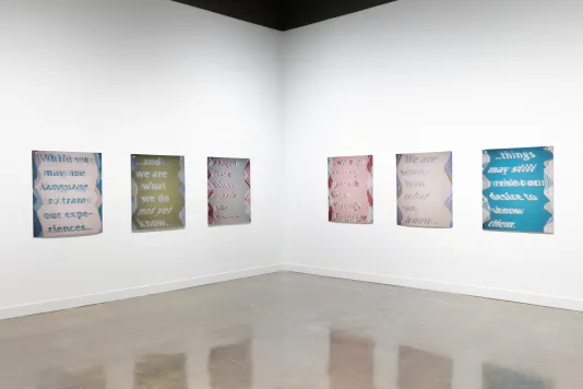 Installation view featuring three colored inkjet prints on vinyl on the left wall and three on the right wall.
