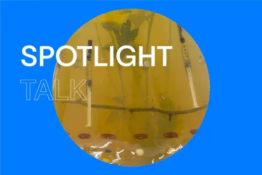 Blue background with a closeup of a yellow gelatin sculpture in a circle in the center with title on the left that reads "Spotlight Talk"