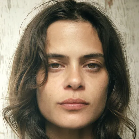 Headshot of Lexie Smith, a fair skinned woman with tousled brown hair and brown eyes, wearing a black shirt