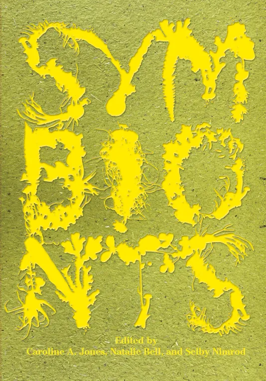 Book cover for &quot;Symbionts&quot; featuring a green background on textured paper and the title of the book spelled out in large stenciled letters in three rows with three letters in each row in bright yellow.