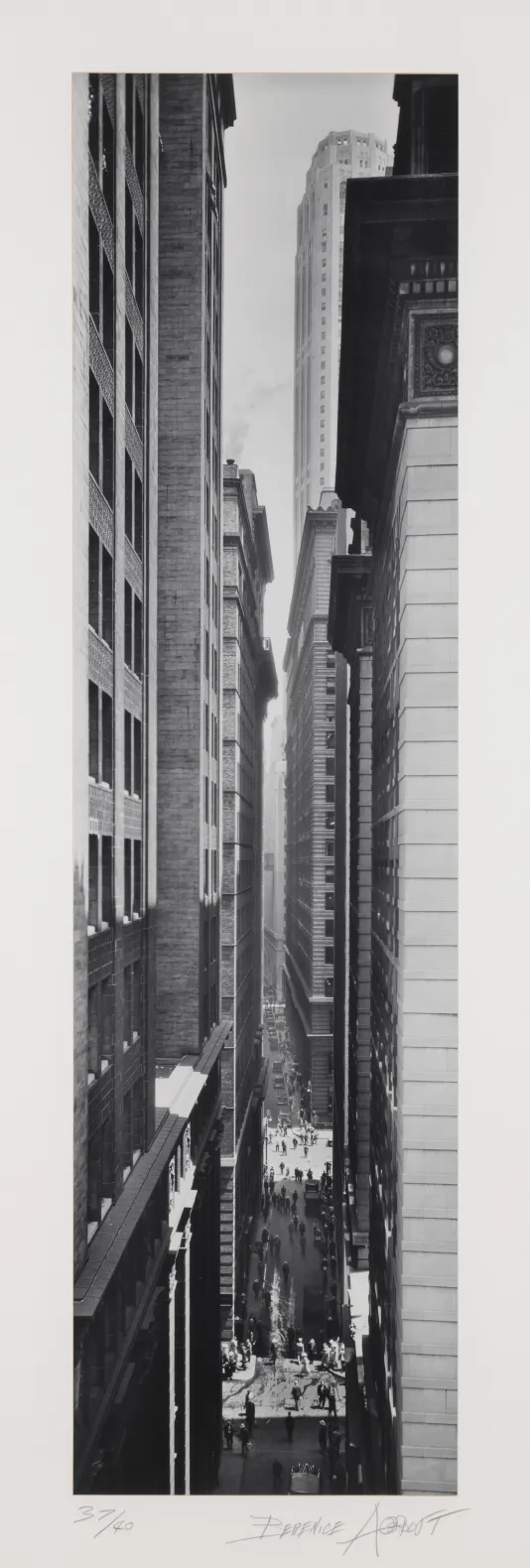 Tall vertical photograph taken between two rows of tall New York City buildings.