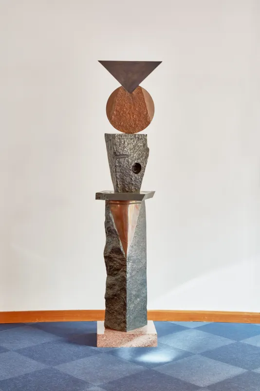 Bronze sculpture featuring different shapes stacked on top of one another.