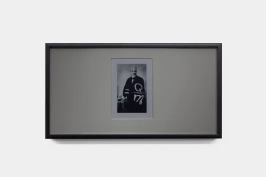 A small black-and-white portrait photograph of inventor Norbert Rillieux set in a large mat is overlaid with white text that reads: L=Qm, the equation for latent heat. The framed work has a grey tint from the privacy filter that serves as glass. 