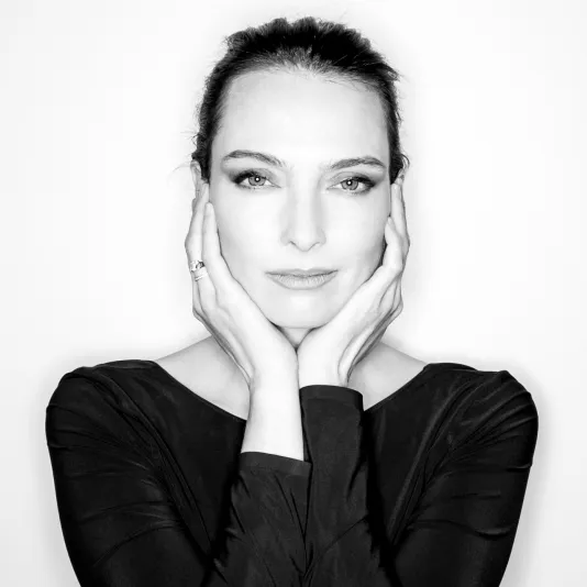 Black and white portrait of Lia Chavez with her hands holding either side of her face.