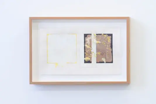 Rectangular painting with a light tan wood frame and a white matte. Two squares comprise the work. The left square is white with a thin yellow border and the right square is brown with accents of yellow organically throughout and a white bar cuts the brown square straight down the left-hand vertical third.