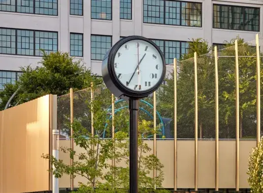 A freestanding clock with a restrained modern design sits seamlessly into the built environment of the Kendall Open Space plaza