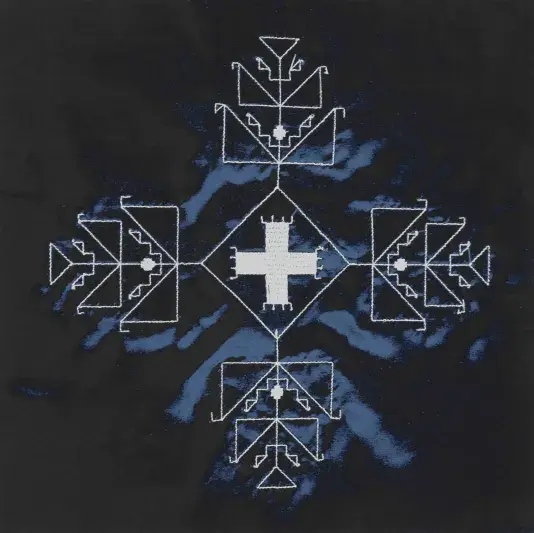 A white geometric form is embroidered on a dark background. There are ripples of blue sheen in the fabric.