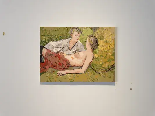 A golden-green painting in a 19th-century European style shows two women half-reclining: The one in the foreground is topless, and seems almost cradled by her clothed companion, who leans over her. The painting is crude and seems separated into layers of uniformly applied color.  The white wall around the painting is marked by golden hanging hardware and irregular square of tape-like material.