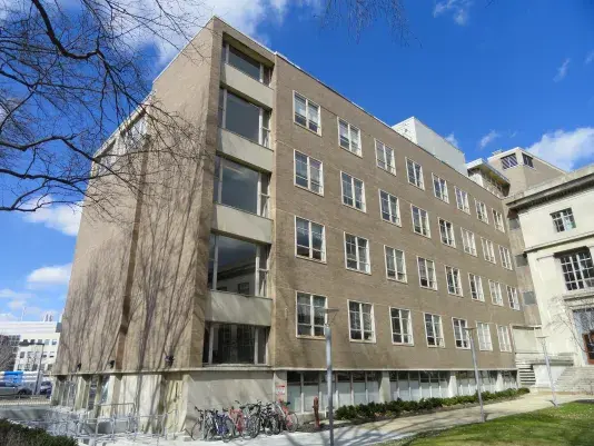 Grey and white building with lots of windows and some bikes out front.
