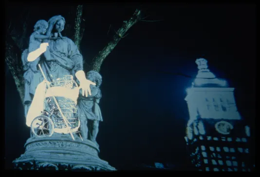 Photo of a statue of a woman and children overlaid with a projection with a building in back.