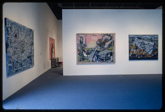Three large tapestries of landscapes hang on adjacent gallery walls.