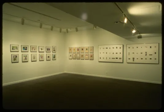 Photographs line the walls of the gallery. Photos are grouped together with others in their series or are framed together. 