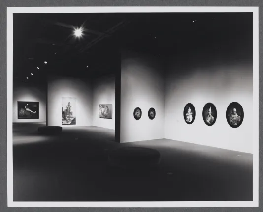 Figurative portraits are displayed in different shapes. For example, a series of three circular portraits are hung together. 