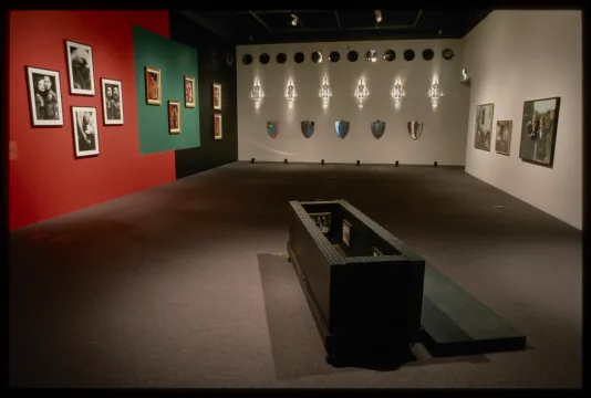 An installation view of The Masculin Masquerade showing photographic and sculptural works.