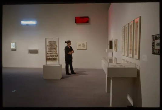 Viewer looking at art in the back of the gallery.