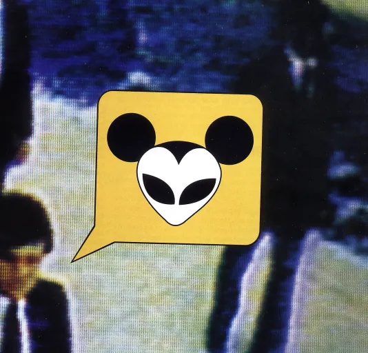 A cartoon word bubble contains a stylized Mickey Mouse with alien eyes. It sits on top of a blurred scene with 2 businessmen.